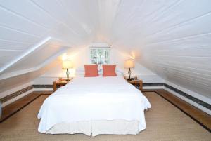 基韦斯特西蒙顿庭院历史小屋宾馆的卧室配有白色的床和两盏灯。