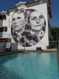 纳扎雷Casa do Joaquim da Praia的一座带游泳池的建筑的侧面壁画