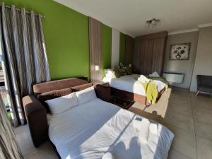 勒斯滕堡Green Side accommodation的酒店客房,设有两张床和一张沙发