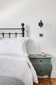 沃里克Warwick Post Office Apartment的一间卧室配有一张床和一个带白色床单的绿色床头柜。