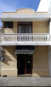 韦拉克鲁斯Hotel Posada San Juan的黄色的建筑,设有阳台和门