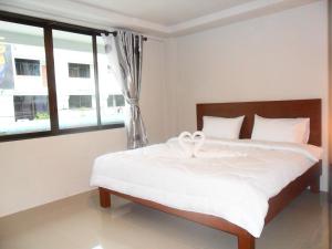 甲米镇城市之家旅馆的一间卧室配有一张带白色床单的床和一扇窗户。