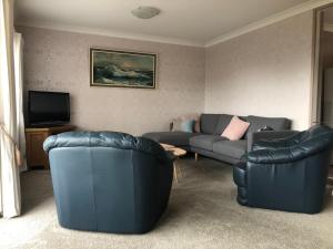 奥克兰Central Howick Uxbridge Apartments的客厅配有两张沙发和一台电视机