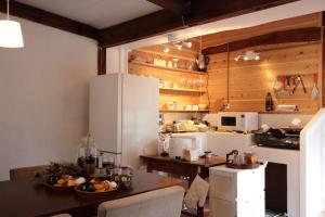 境港市Little Bird Inn 旧Minato Guesthouse的厨房配有桌子和白色冰箱。