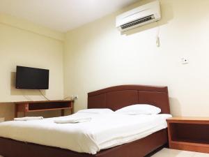 米里HK Inn Hua Kiew Inn的卧室配有一张床,墙上配有电视。