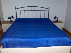 德尔维奥斯蒂夫别墅旅馆的床上有蓝色的被子