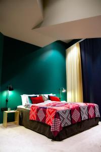 斯德哥尔摩柏酒店的一间卧室配有一张带绿色墙壁的床