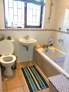 开普敦The Speckled Egg, 4 Promenade Rd, Lakeside, Cape Town的浴室配有卫生间、盥洗盆和浴缸。
