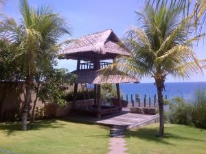 艾湄湾武吉瑟加拉别墅酒店的海滩上的凉亭,种植了棕榈树