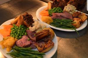 FeltonThe George & Dragon的两盘食物,有肉和蔬菜放在桌上