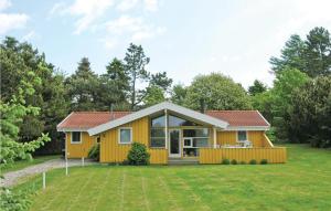 Udsholt SandCozy Home In Grsted With Kitchen的一座黄色的小房子,有大院子