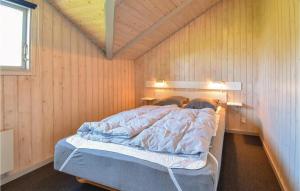 博恩瑟Awesome Home In Bogense With 3 Bedrooms And Wifi的卧室配有木墙内的一张床