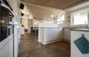 KelstrupGorgeous Home In Haderslev With Sauna的一间厨房,配有白色橱柜和一间餐厅
