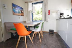 奥德多普Ferienhaus Mosselbank 109 Noordzeepark - Ouddorp - not for companies的厨房配有木桌和两把椅子