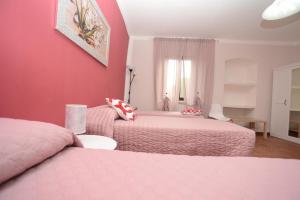 BoianoCasetta Margret的一间卧室设有两张床和粉红色的墙壁