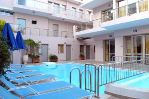 罗希姆诺蓝天酒店式公寓的酒店游泳池设有蓝色躺椅