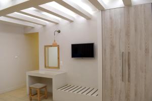 罗希姆诺蓝天酒店式公寓的一间设有镜子的客房,墙上配有电视