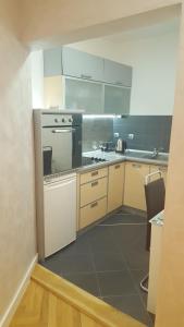 贝尔格莱德Arena Relax Apartman的厨房配有白色橱柜和炉灶。