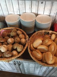 格赖夫斯瓦尔德Der LeuchtTurm-Gastro GmbH的两个装满不同种类面包和盘子的篮子