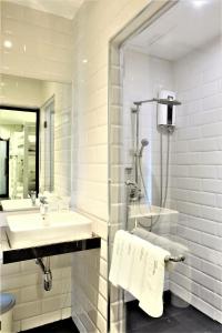 曼谷马尔温空间旅馆的白色的浴室设有水槽和淋浴。