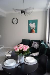 托伦Green Park Apartament的客厅配有沙发和粉红色玫瑰桌