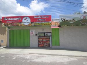 波苏斯-迪卡尔达斯Recanto das Rosas的一间设有绿色门和标志的快餐店
