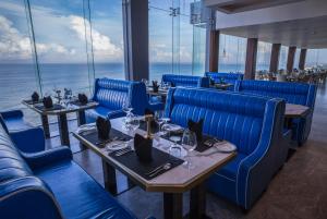 尼甘布Regal Réseau Hotel & Spa的一间设有蓝色桌椅的海洋餐厅