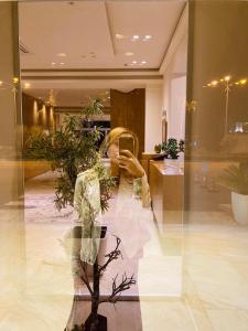 培拉特大白城酒店的女人在窗口里拍照片的反射