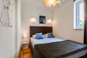 巴斯卡Apartments Adria Garden的一间卧室配有一张带蓝色枕头的大床