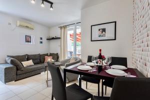 巴斯卡Apartments Adria Garden的客厅配有桌椅和沙发