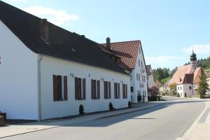 卡斯托Land-gut-Hotel Forsthof的一条白色的街道上,有黑色屋顶
