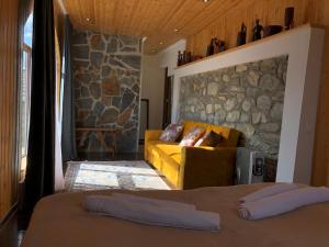梅斯蒂亚Guest House Keti Margiani Mestia的带沙发和石墙的客厅