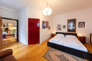 格拉茨六十年代公寓的一间卧室设有一张大床和一扇红色的门