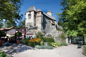 阿尔普巴赫谷地赖特Schloss Matzen的一座古老的石头建筑,前面有一个花园