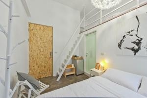 高雄理欧111/巨蛋瑞丰馆的卧室配有白色的床和楼梯。