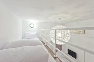 高雄理欧111/巨蛋瑞丰馆的一间白色卧室,配有两张床和植物