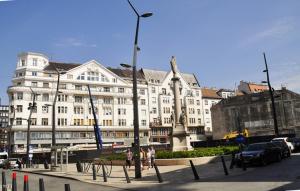 布达佩斯可穆北凯斯旅舍的一座白色的大建筑,前面有雕像