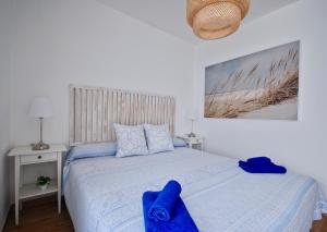大塔拉哈尔Sky Lovers Jacuzzi Fuerteventura的一间卧室配有一张带蓝色毛巾的床