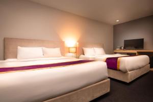 吉隆坡Royce Hotel @ KL Sentral的酒店客房设有两张床和一台平面电视。