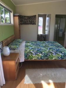 芒阿法埃Chalet Cullen,的一间卧室配有一张带绿色和蓝色床单的床