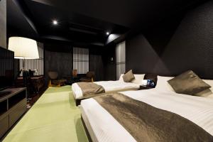 横滨横滨马车道PROSTYLE日式旅馆的酒店客房设有两张床和电视。