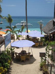 邦劳Hayahay Resort的海滩上的一组桌子和遮阳伞