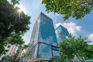 深圳深圳金中环服务公寓-深业上城店 Golden Central Serviced Residence Shenzhen-UpperHills的天空中阳光灿烂的高高的玻璃建筑