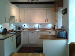 彭里斯Millcroft的厨房配有白色橱柜和水槽