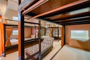 曼谷瑞思提尼旅舍的客房设有双层床、沙发和椅子。