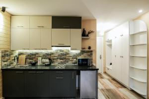 古多里New Gudauri Loft2 #433的厨房配有白色橱柜和黑色台面