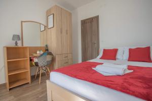 赫尔采格诺维Apartments Gvozdenovic的一间卧室配有一张带红色枕头的大床