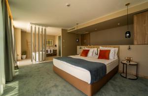 帕莫瑞Wave Resort - Ultra All Inclusive的大卧室配有带橙色枕头的大床
