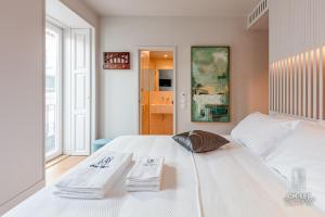 里斯本ON/SET Alfama - Lisbon Cinema Apartments的卧室配有白色床和毛巾