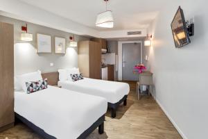 米卢斯Appart'City Confort Mulhouse的酒店客房带两张床和厨房